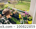 Woman watering flowers at her balcony at spring 100822859