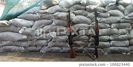 Two Kalashnikovs standing near sandbagged fortifications. AK-74 outdoor 100823440