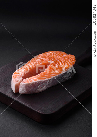 Fresh raw red fish steak with spices and herbs Fresh raw red fish steak with spices and herbs 100824348