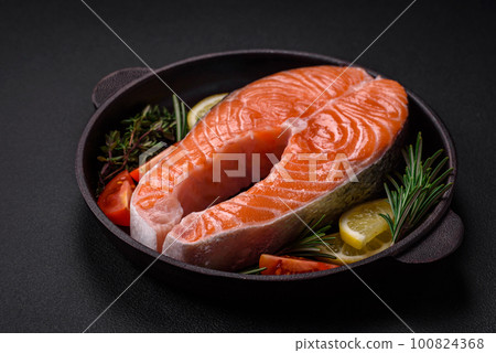 Fresh raw red fish steak with spices and herbs 100824368