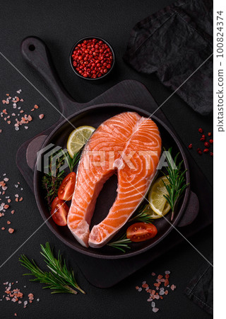 Fresh raw red fish steak with spices and herbs 100824374