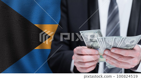 Hands holding dollar money on flag of Bahamas Hands holding dollar money on flag of Bahamas 100824519