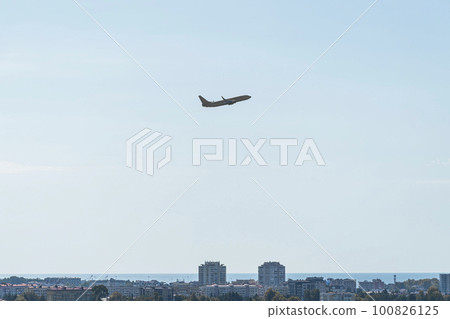 the plane is flying against a background of blue sky and sun the plane is flying against a background of blue sky and sun 100826125