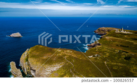 Cliffs At Atlantic Coast With Ancient Lighthouse At Cap Frehel In Brittany, France; Phare du Cap Frehel Cliffs At Atlantic Coast With Ancient Lighthouse At Cap Frehel In Brittany, France; Phare du Cap Frehel 100826557