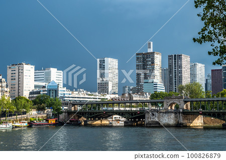 River Seine In Paris, France With Promenade, Anchored Houseboats And Modern Office Buildings 100826879