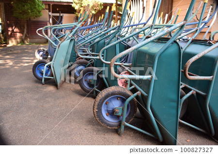 Multiple wheelbarrows leaning against 100827327