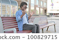 Young African Man Reacting to Loss on Laptop while Sitting Outdoor on Bench 100829715