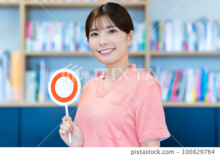 A young woman who is a caregiver who puts out an OK plate 100829764