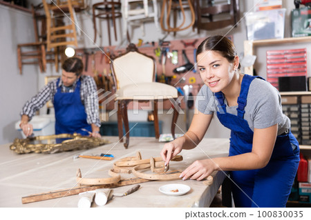 Portrait of skillful repair woman carpenter renovating chair furniture using tools in woodwork studio 100830035