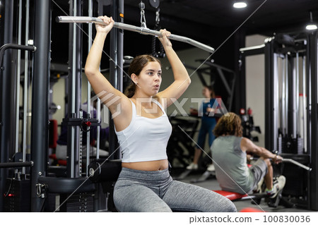 Woman is engaged in a simulator for development of back muscles 100830036
