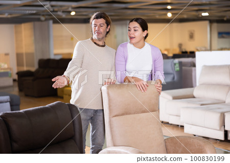 Happy couple choose a new armchair Happy couple choose a new armchair 100830199