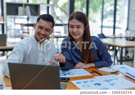 startup business, portrait of two entrepreneurs using computers and financial budget documents to make marketing plans to increase profits. startup business, portrait of two entrepreneurs using computers and financial budget documents to make marketing plans to increase profits. 100830254