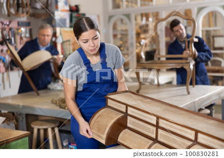 Young female carpenter working on making vintage commode in workshop Young female carpenter working on making vintage commode in workshop 100830281