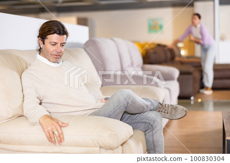Man picking out sofa in furniture store Man picking out sofa in furniture store 100830304