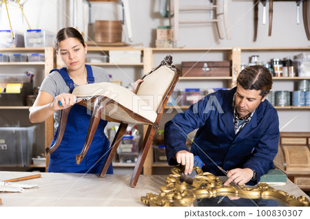 employees restore antique chair with twisted legs and mirror in massive carved wooden frame 100830307