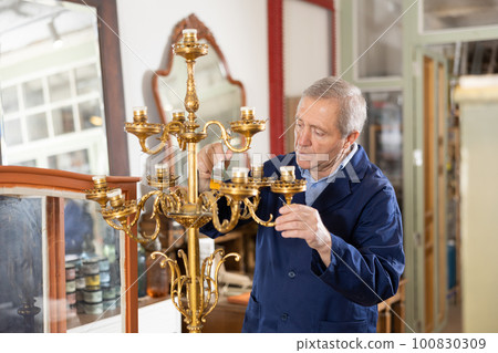 Craftsman restores vintage chandelier in the restoration workshop 100830309