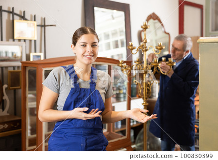 Happy young female furniture worker welcoming inside his workshop Happy young female furniture worker welcoming inside his workshop 100830399