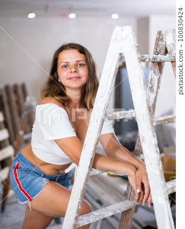 Young seductive woman posing in apartment during repair works 100830424