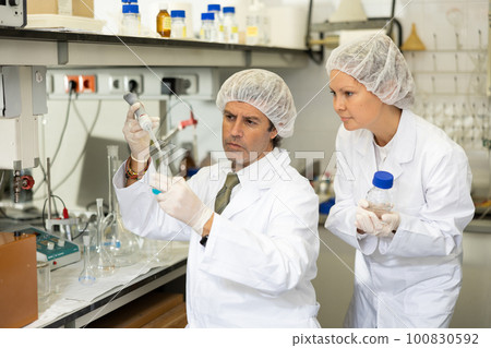 Man and woman scientists chemists conduct experiments in the laboratory 100830592