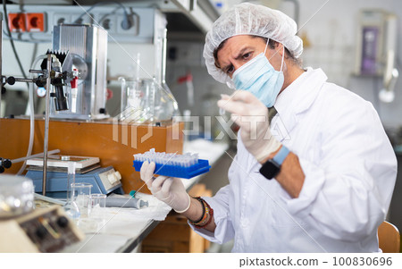 Focused man technician working in research laboratory 100830696