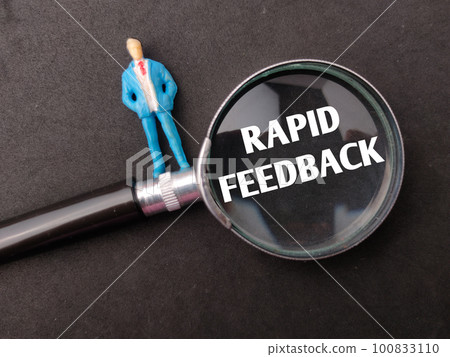 Miniature people and magnifying glass with the word RAPID FEEDBACK on black background. Business concept. Miniature people and magnifying glass with the word RAPID FEEDBACK on black background. Business concept. 100833110