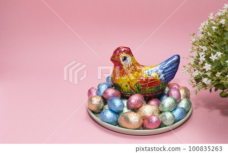 Paschal, Easter kids gift. Chocolate hen, little chickens with colorful bright sweet eggs wrapped in foil, flower on pink background. Confectionery, sweet-shop concept.Copy space for text, horizontal Paschal, Easter kids gift. Chocolate hen, little chickens with colorful bright sweet eggs wrapped in foil, flower on pink background. Confectionery, sweet-shop concept.Copy space for text, horizontal 100835263