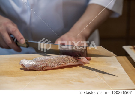 Hands of a sushi chef handling throat black 100836507