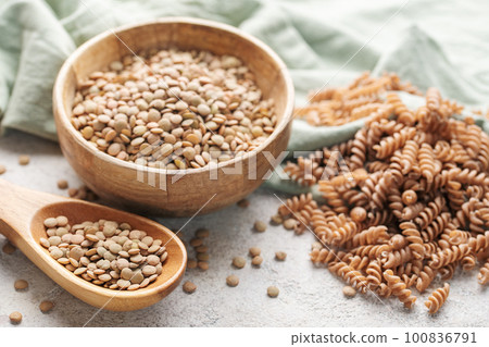 Green lentil fusilli pasta on a gray concrete background. 100836791