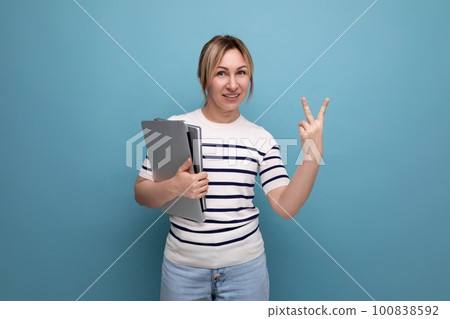 horizontal photo of attractive business woman in casual striped sweater with laptop showing two 100838592