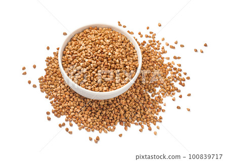 Full buckwheat bowl in the middle of buckwheat pile isolated on white background. Top view Full buckwheat bowl in the middle of buckwheat pile isolated on white background. Top view 100839717