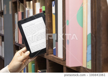hand selecting, choosing a book 100841061