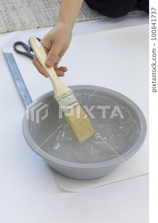 DIY interior hand motion, closeup_apply paste to wallpaper 100841737