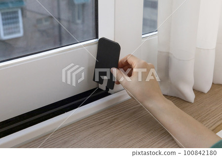 DIY interior hand motion, closeup_put up paper weather strip 100842180