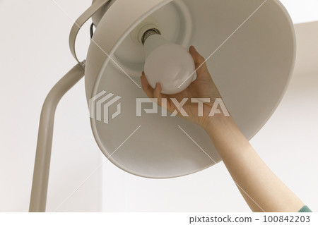 DIY interior hand motion, closeup_changing light bulbs 100842203