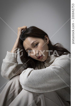stressed, depressed Korean business woman in pink suit, frustrated stressed, depressed Korean business woman in pink suit, frustrated 100842753