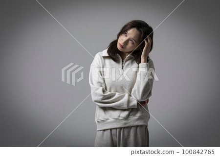 stressed, depressed Korean business woman in pink suit, worrying 100842765