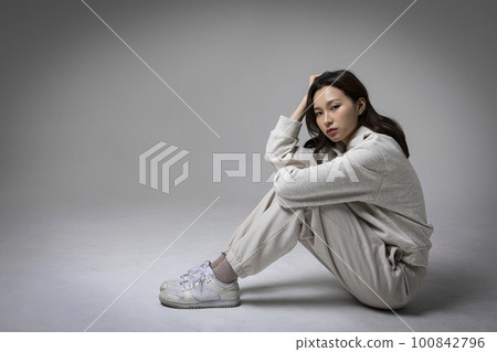 stressed, depressed Korean business woman in pink suit, frustrated stressed, depressed Korean business woman in pink suit, frustrated 100842796