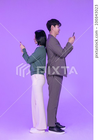 business working concept, young Korean Asian woman and man holding mobile phone with empty screen 100843023