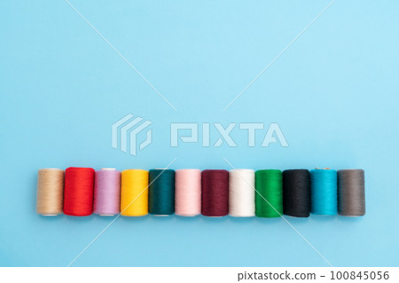 Row of colored spools with sewing threads close up and place for inscription Row of colored spools with sewing threads close up and place for inscription 100845056