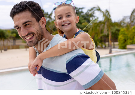 Portrait of happy biracial father and daughter embracing by the swimming pool Portrait of happy biracial father and daughter embracing by the swimming pool 100845354