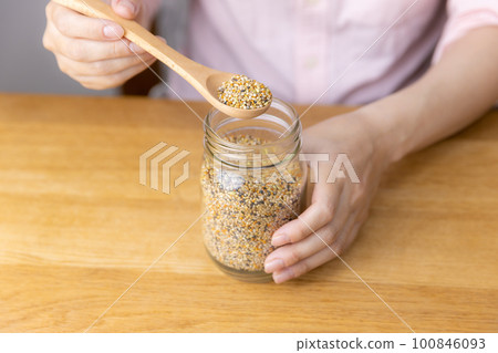 A woman scooping food for small birds A woman scooping food for small birds 100846093