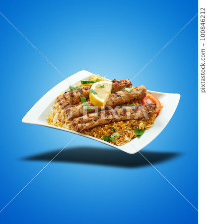 Floating Kabab Biryani on white plate on blue gradient 100846212