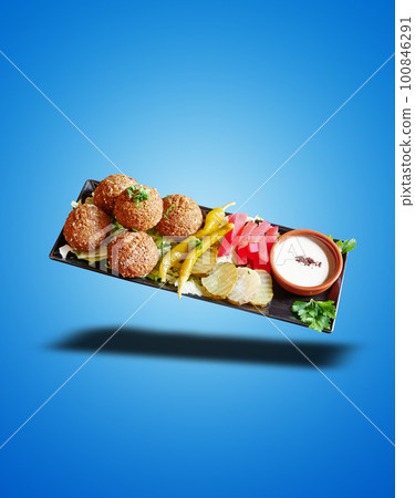 Floating Black plate with Falafel apetizer on blue gradient Floating Black plate with Falafel apetizer on blue gradient 100846291