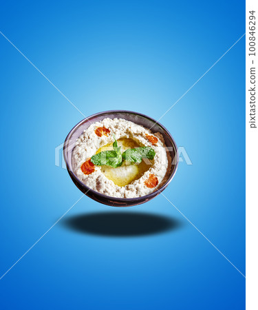 Floating Black bowl with Moutabal apetizer on blue gradient Floating Black bowl with Moutabal apetizer on blue gradient 100846294