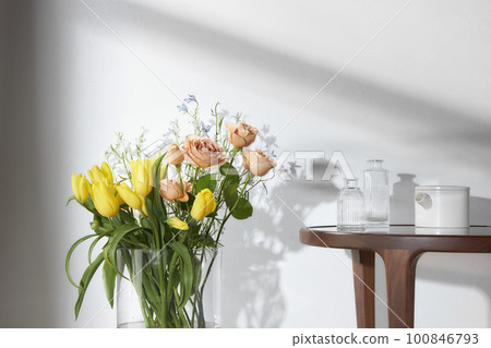 A cozy home with sunlight shining through the windows and fresh flowers A cozy home with sunlight shining through the windows and fresh flowers 100846793