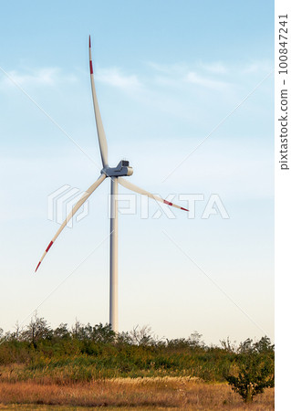 Silhouette of wind turbines at sunset. The concept of alternative energy. Silhouette of wind turbines at sunset. The concept of alternative energy. 100847241