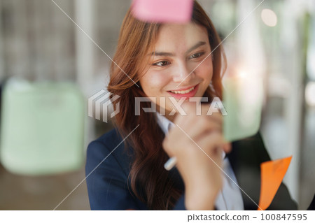 Beautiful young teen asian businesswoman using note pad thinking with planning working on financial document, tax, exchange, accounting and Financial advisor. Beautiful young teen asian businesswoman using note pad thinking with planning working on financial document, tax, exchange, accounting and Financial advisor. 100847595