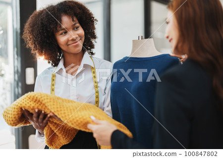 Multi ethnic young teen african american and asian woman fashion designer stylish and friend working at fashion Business studio. 100847802
