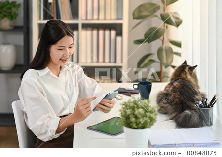 Cheerful millennial woman reading news online, checking social media on mobile phone. People, technology and lifestyle concept 100848073