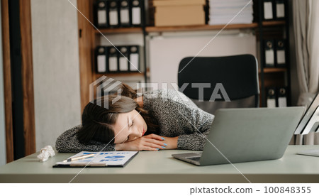 Asian business woman is stressed, bored, and overthinking from working on a tablet at the modern office.. Asian business woman is stressed, bored, and overthinking from working on a tablet at the modern office.. 100848355